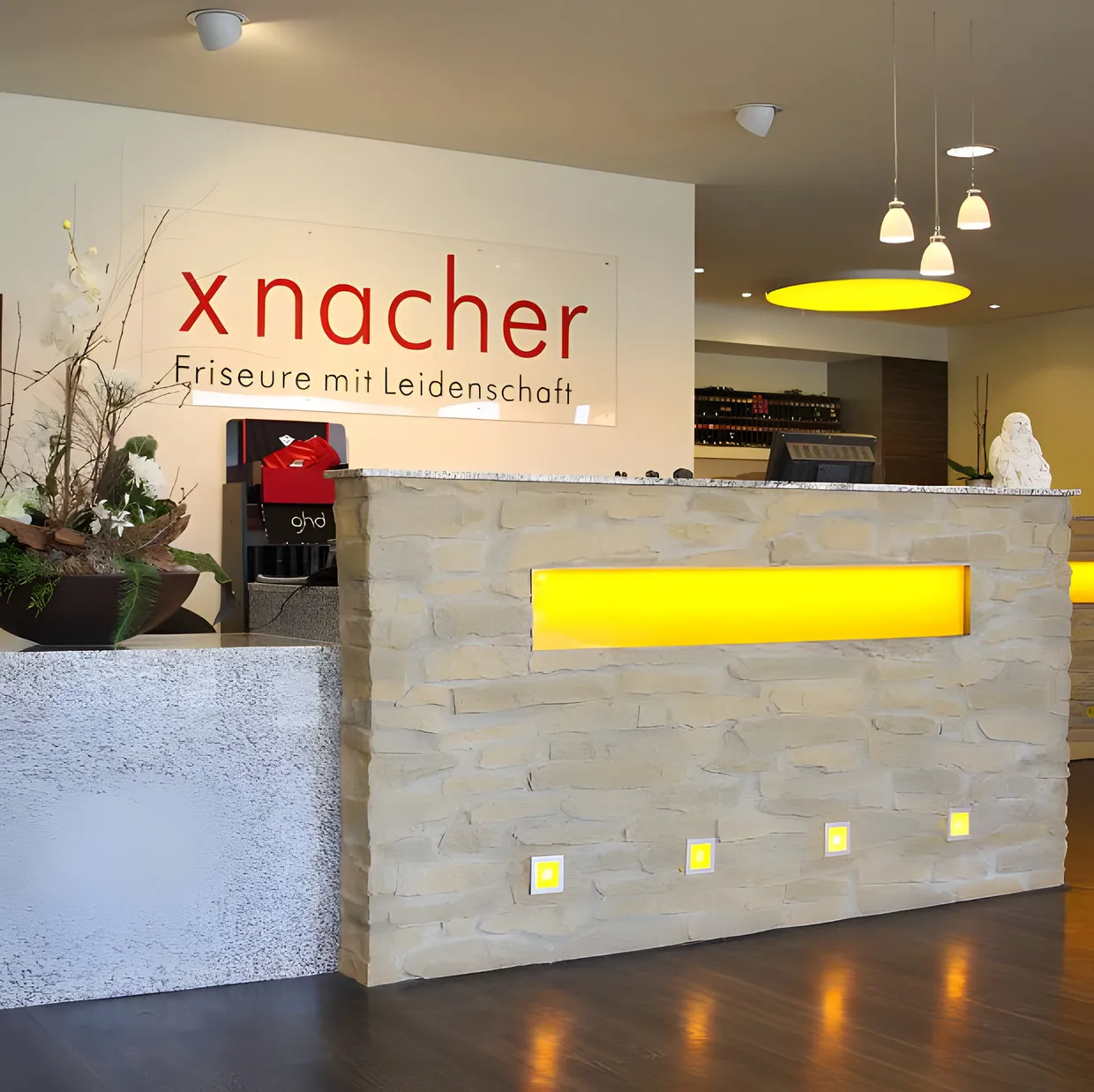 Empfangstresen mit Natursteinwand und dem xnacher-Schriftzug